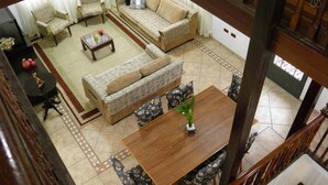 A spacious living area with a sofa set, a coffee table, and a dining table with chairs. - Pousada Sognares (Guarulhos)