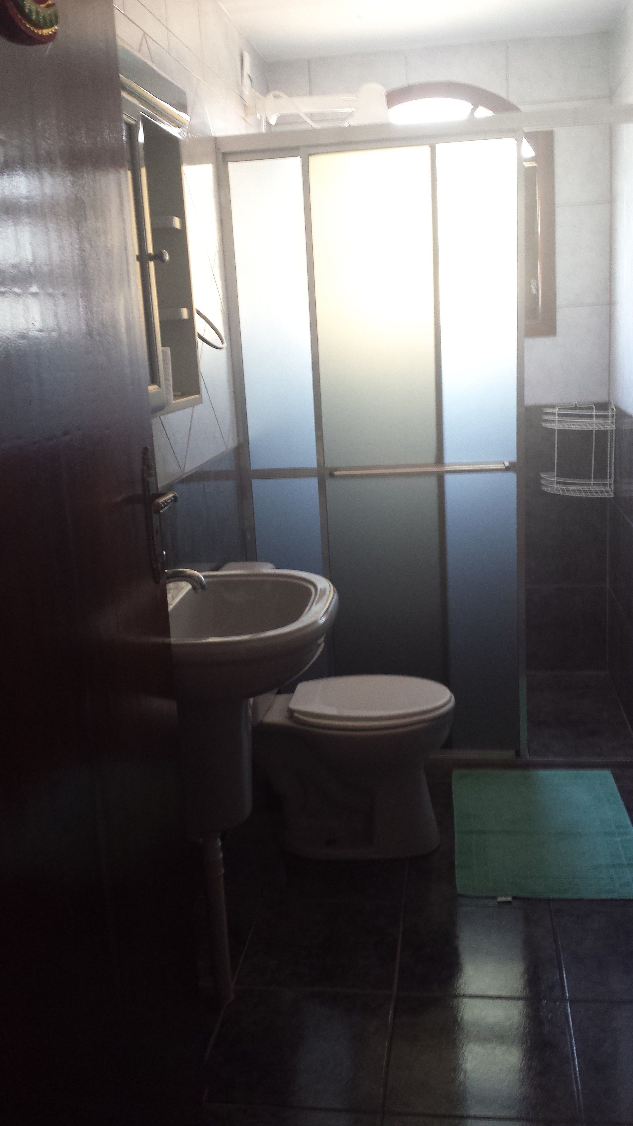 A bathroom with a toilet, sink, and shower area.