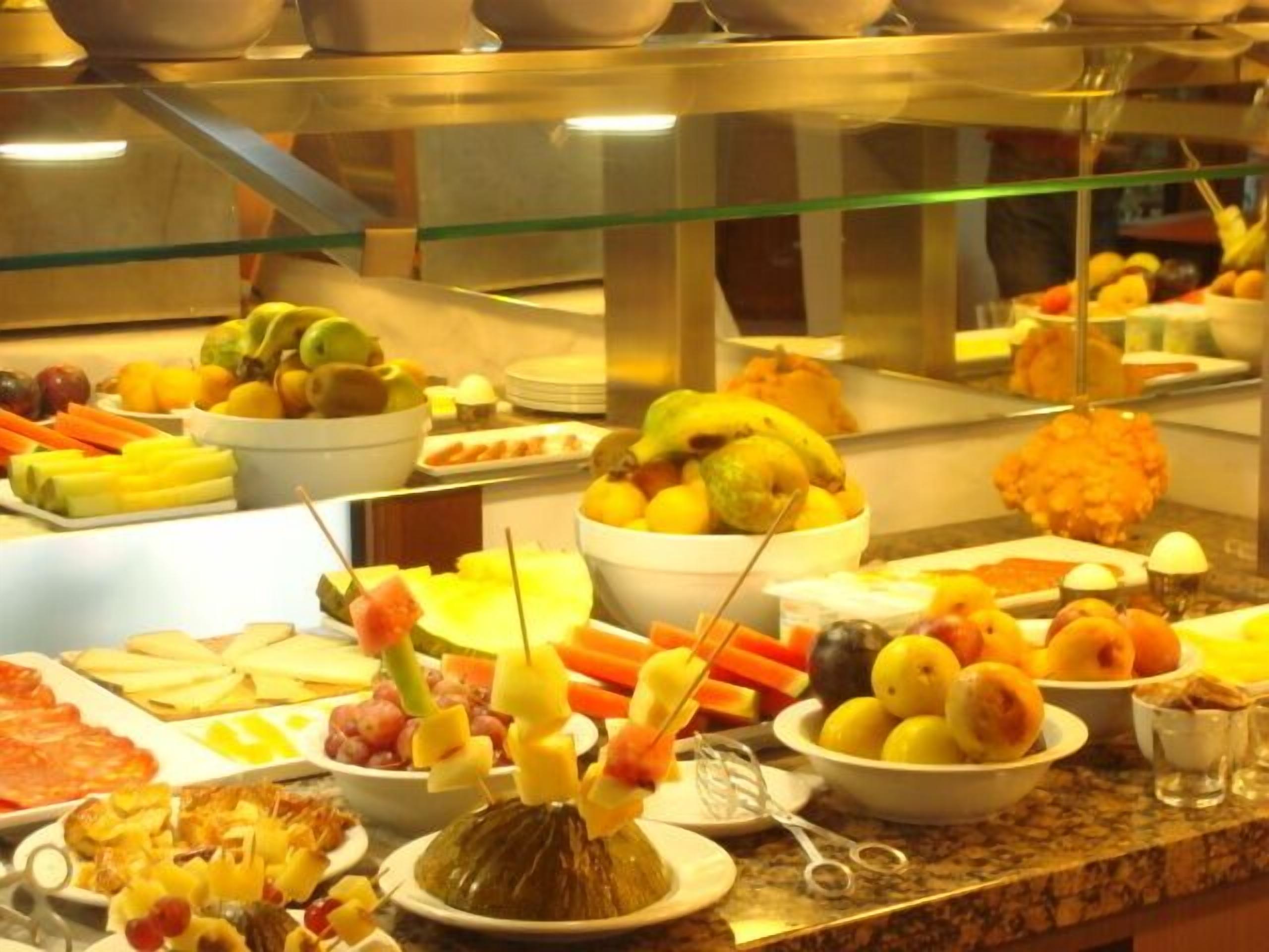 A buffet with various fruits, vegetables, and cheeses.