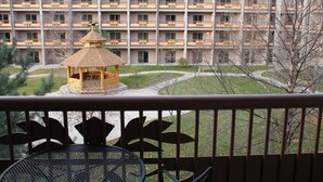 Een hotel met meerdere verdiepingen, balkons en een centrale kiosk.