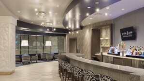 Een bar met een toonbank, barstoelen en een televisiescherm waarop het logo van 'Hochunk Gaming Wisconsin Dell's' staat.