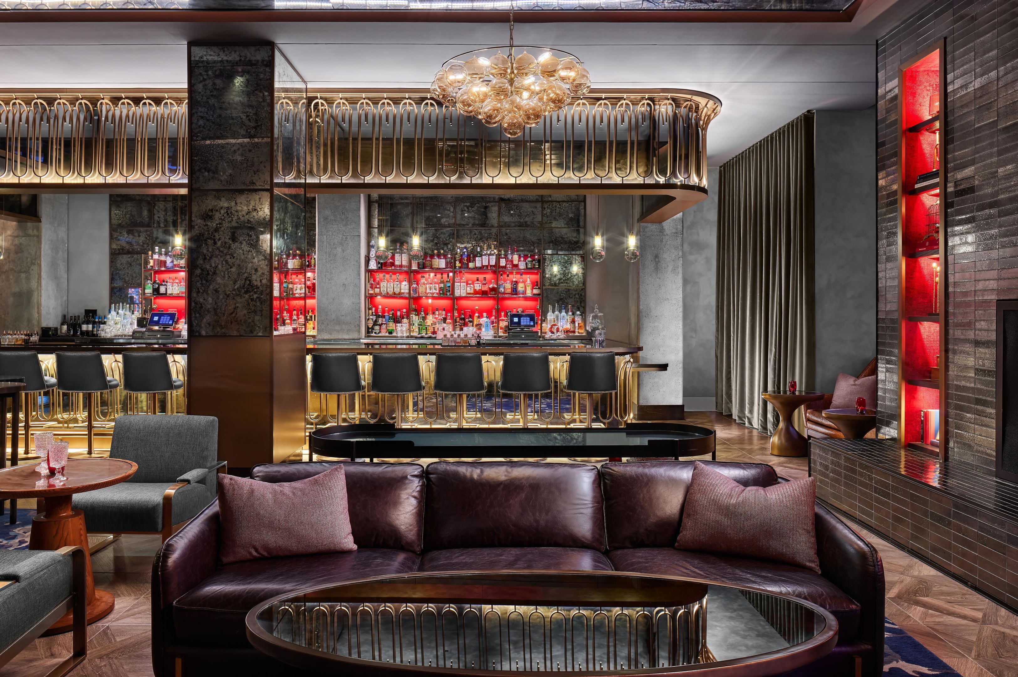 A bar area with seating, a bar counter, and a large chandelier.