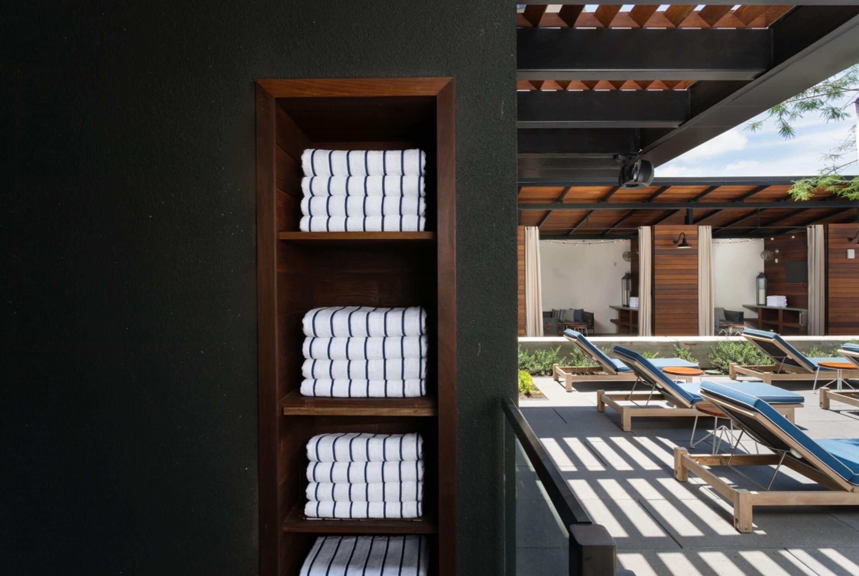 A spa area with sun loungers and a shelf with neatly folded towels.