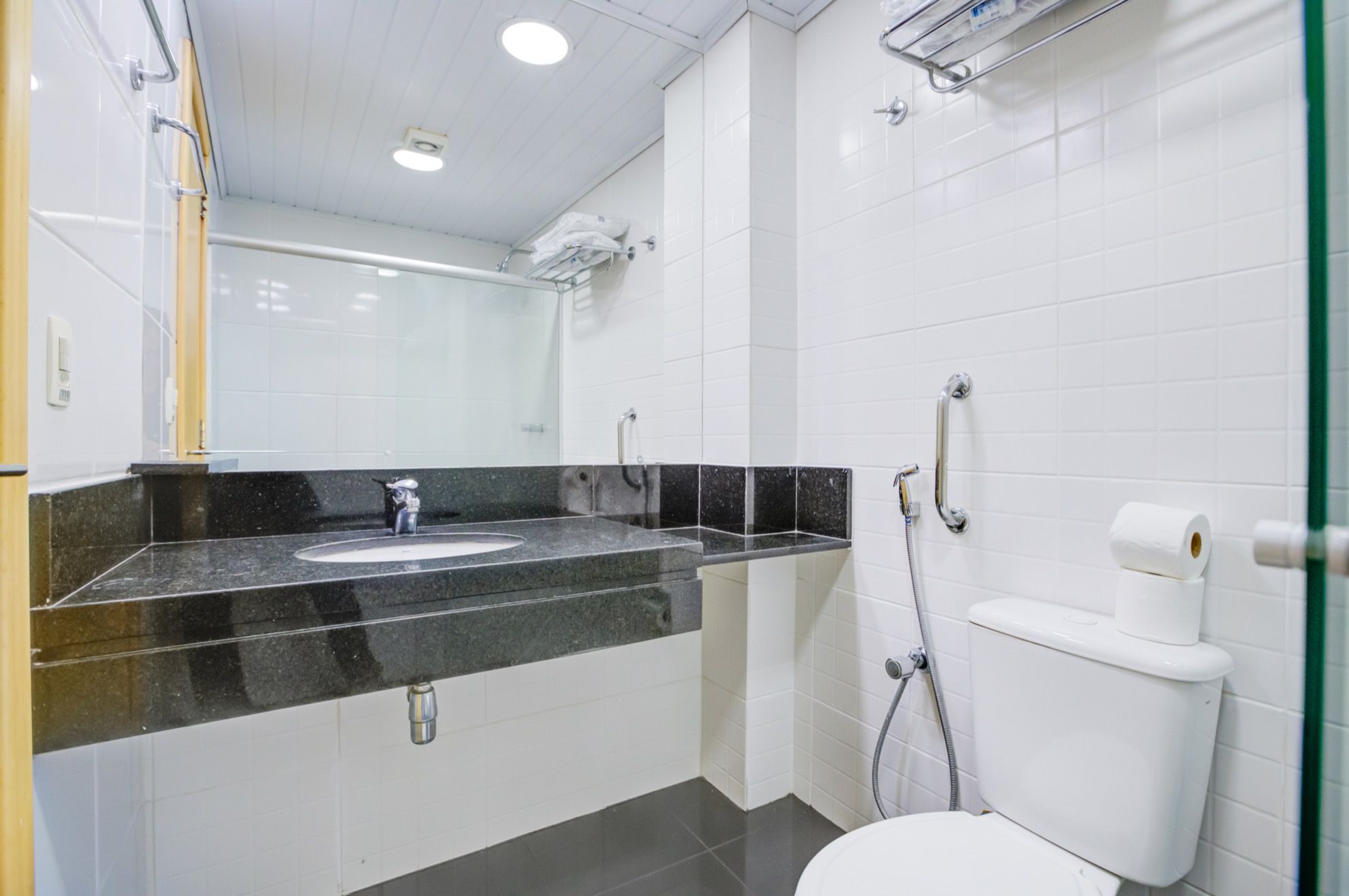 Un baño moderno con tocador doble lavabo, inodoro y zona de ducha.