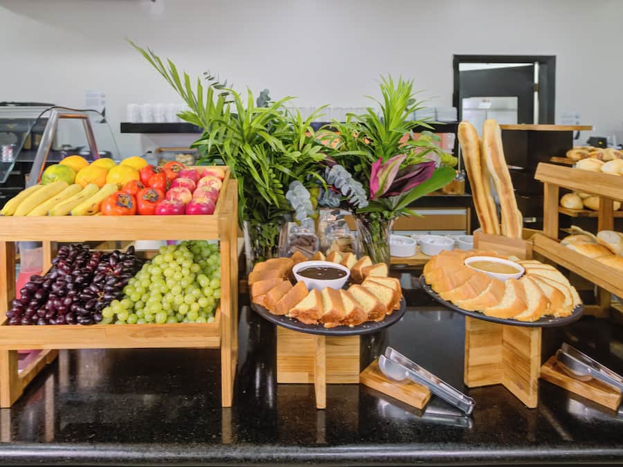 A buffet with various food items including fruits, vegetables, and bread.