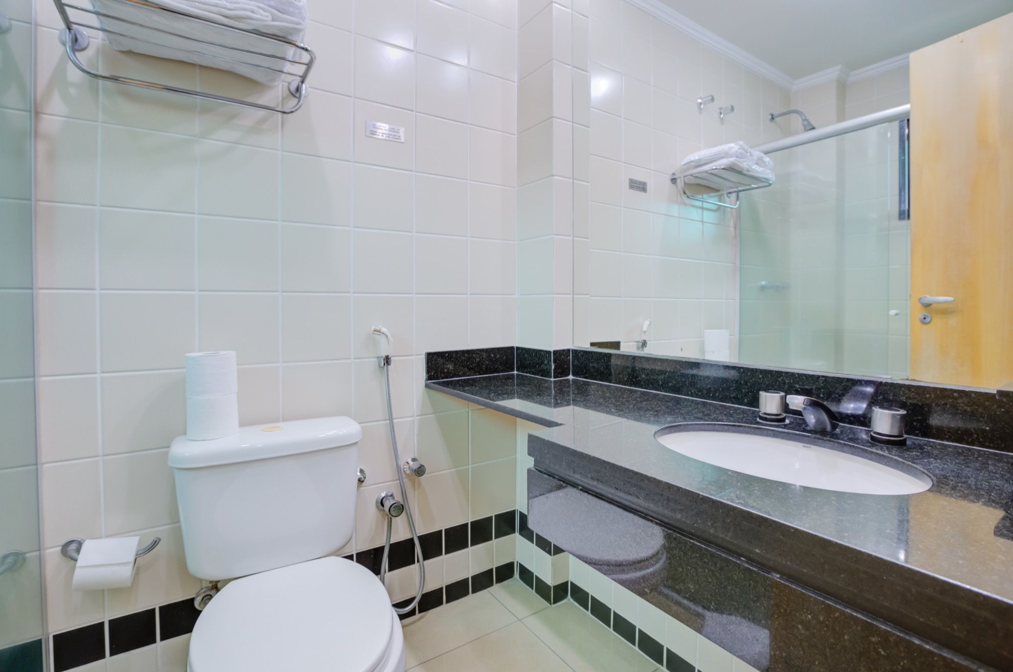 Un baño con inodoro, lavamanos y ducha.