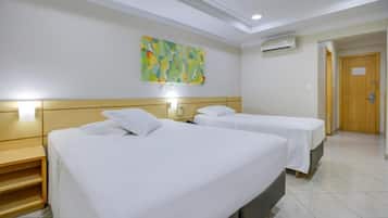 Een hotelkamer met twee bedden, een schilderij aan de muur en een airconditioning.