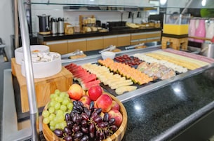 Un bufé con diversas frutas y quesos.