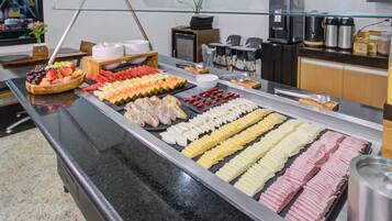 A buffet with various food items including fruits, vegetables, and prepared dishes.