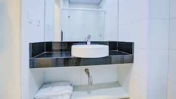A bathroom with a white sink, black countertop, and a mirror above it.