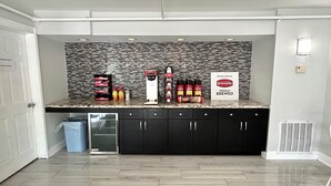 A kitchen with a tiled backsplash, a coffee station, and a sign indicating freshly brewed coffee.