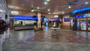 Eine großzügige Lobby mit einer Rezeption, einer Sitzecke und einer dekorativen Springbrunnen.