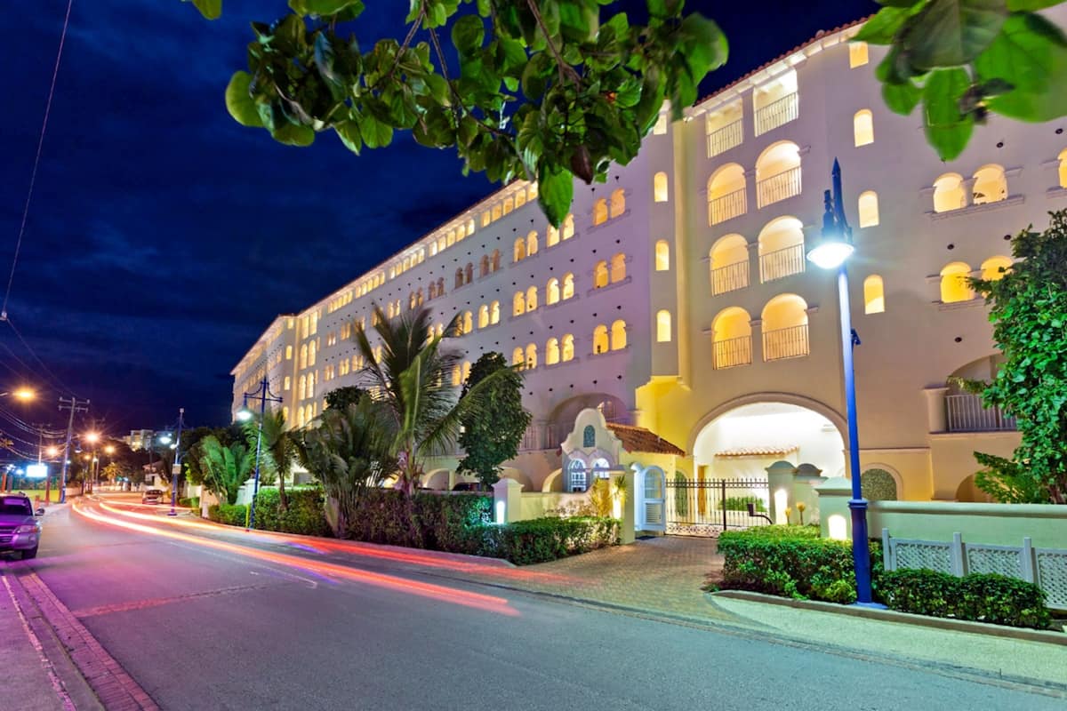 A large, multi-story hotel with a classic architectural style, featuring arched windows and a central courtyard.