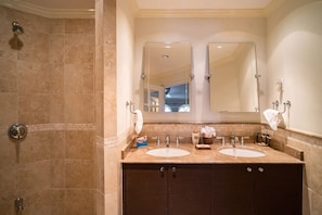 A bathroom with two sinks, a shower, and a large mirror. - Sapphire Beach Condominiums by Blue Sky Luxury (St. Lawrence Gap)