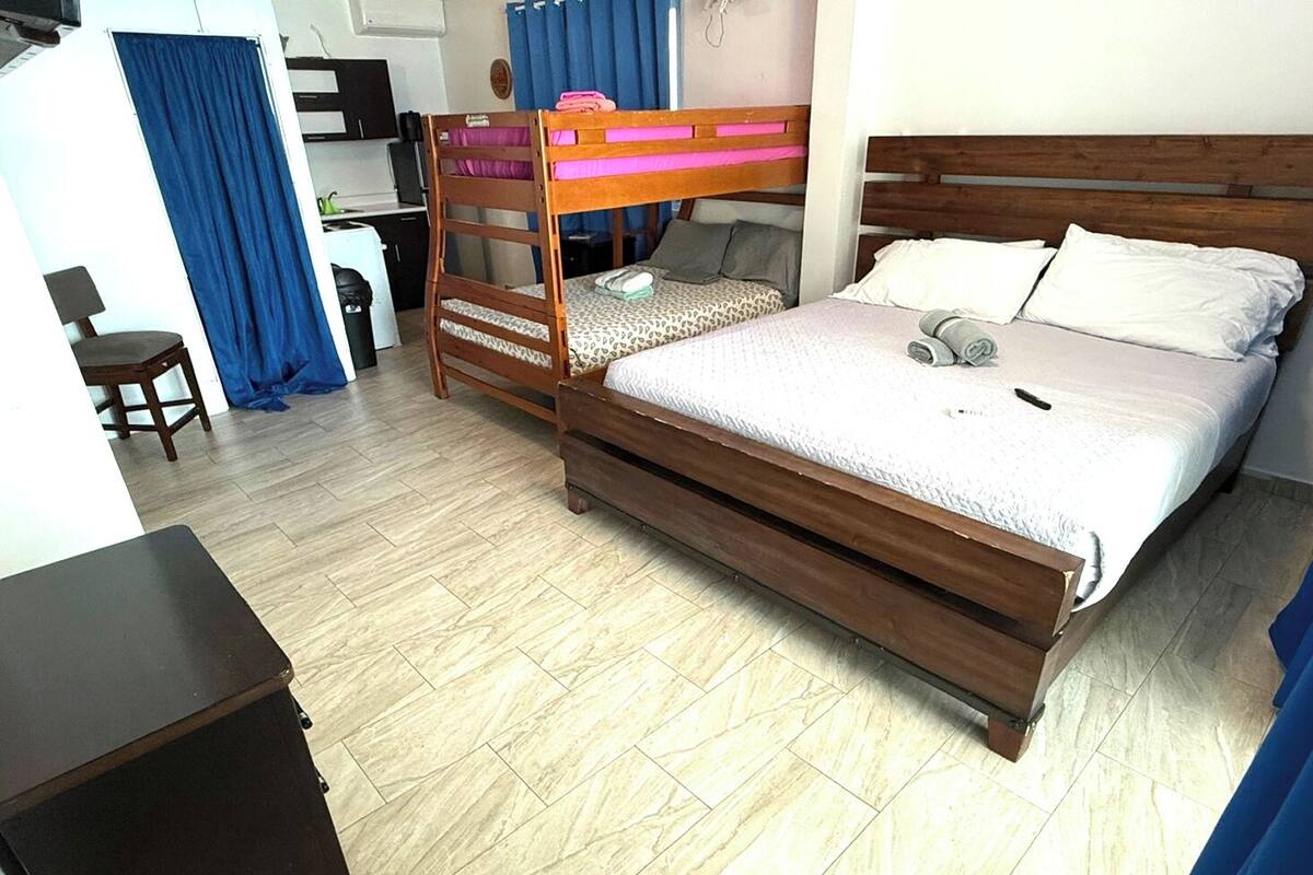Une chambre avec un lit superposé, un bureau, une chaise et une armoire.