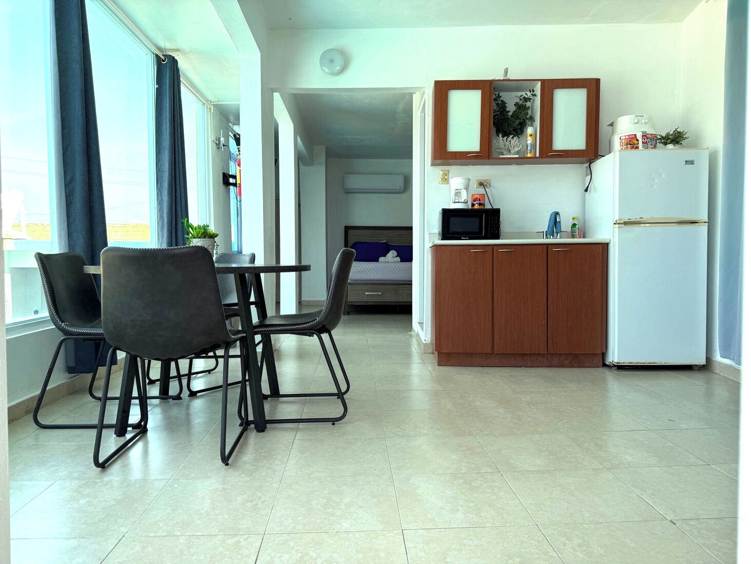 A compact kitchen with a dining area, a microwave, and a refrigerator.