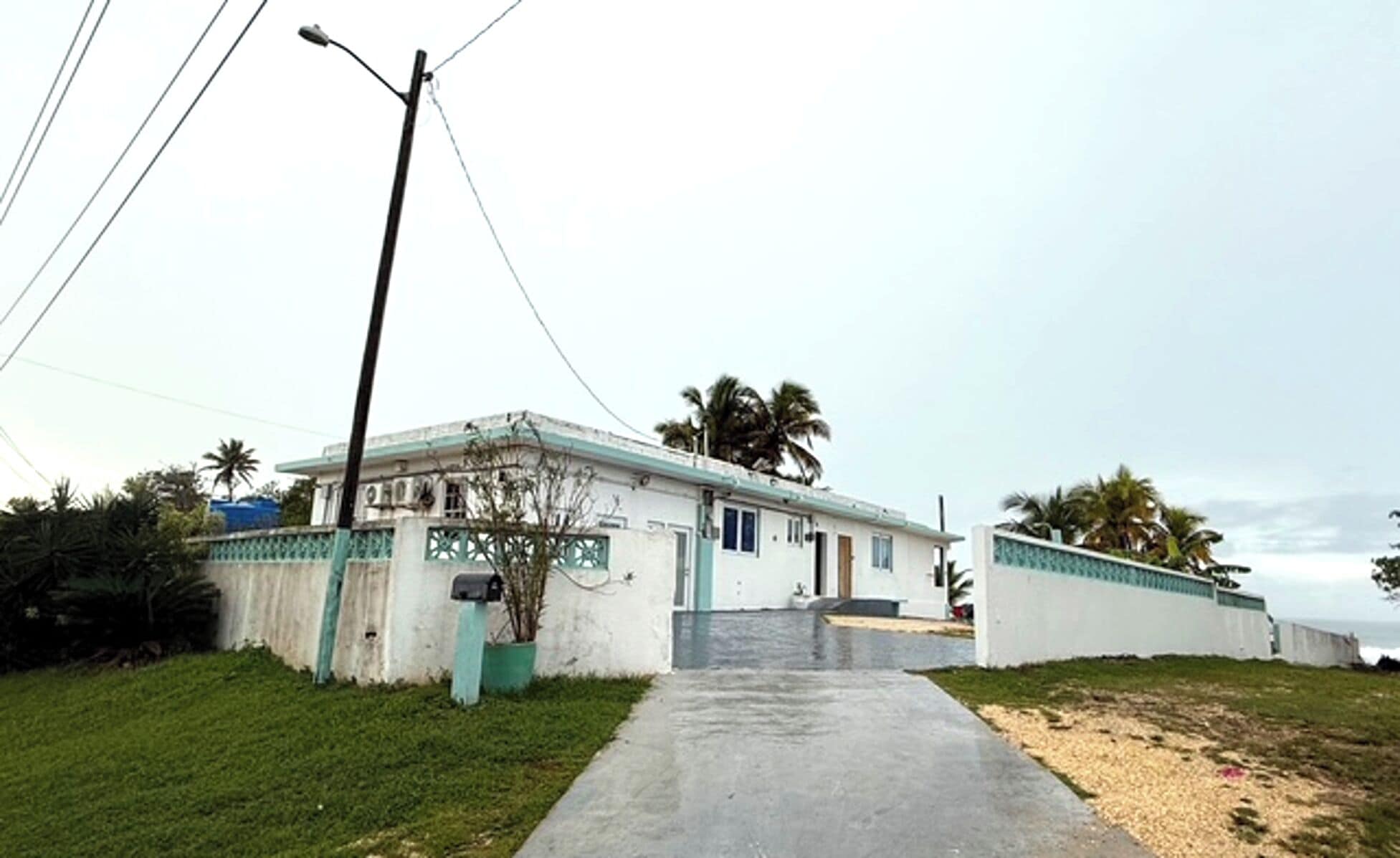 A two-story building with a concrete pathway leading to the entrance.