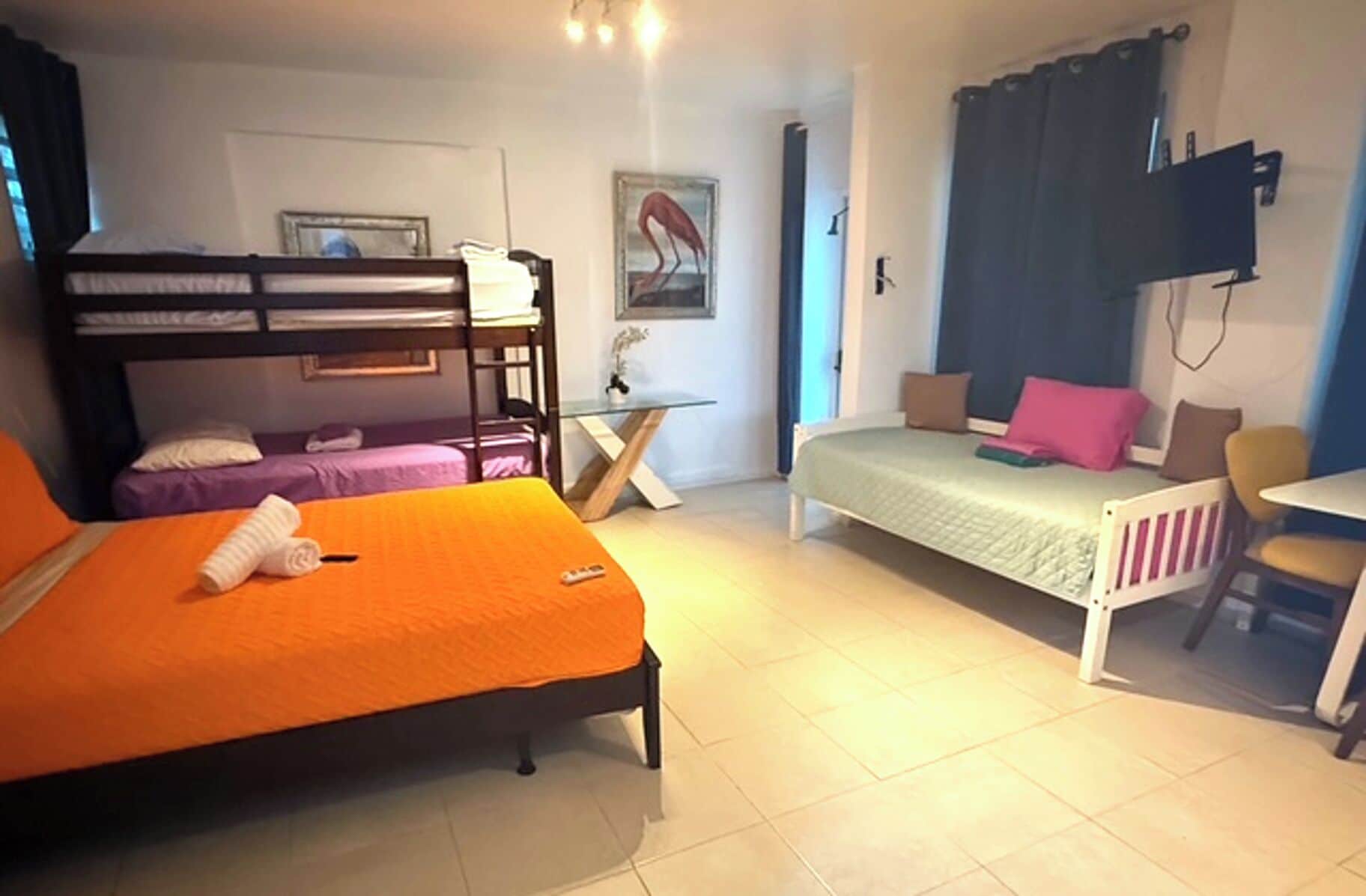 A dormitory room with bunk beds, a desk, and a chair.