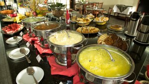 Un bufé con diversos alimentos y utensilios de servicio.