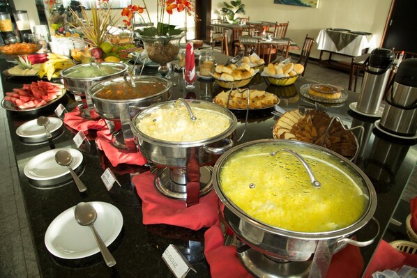 A buffet with various food items and serving utensils.