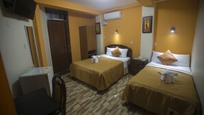 Habitación de hotel con dos camas, un escritorio, una silla y un televisor.