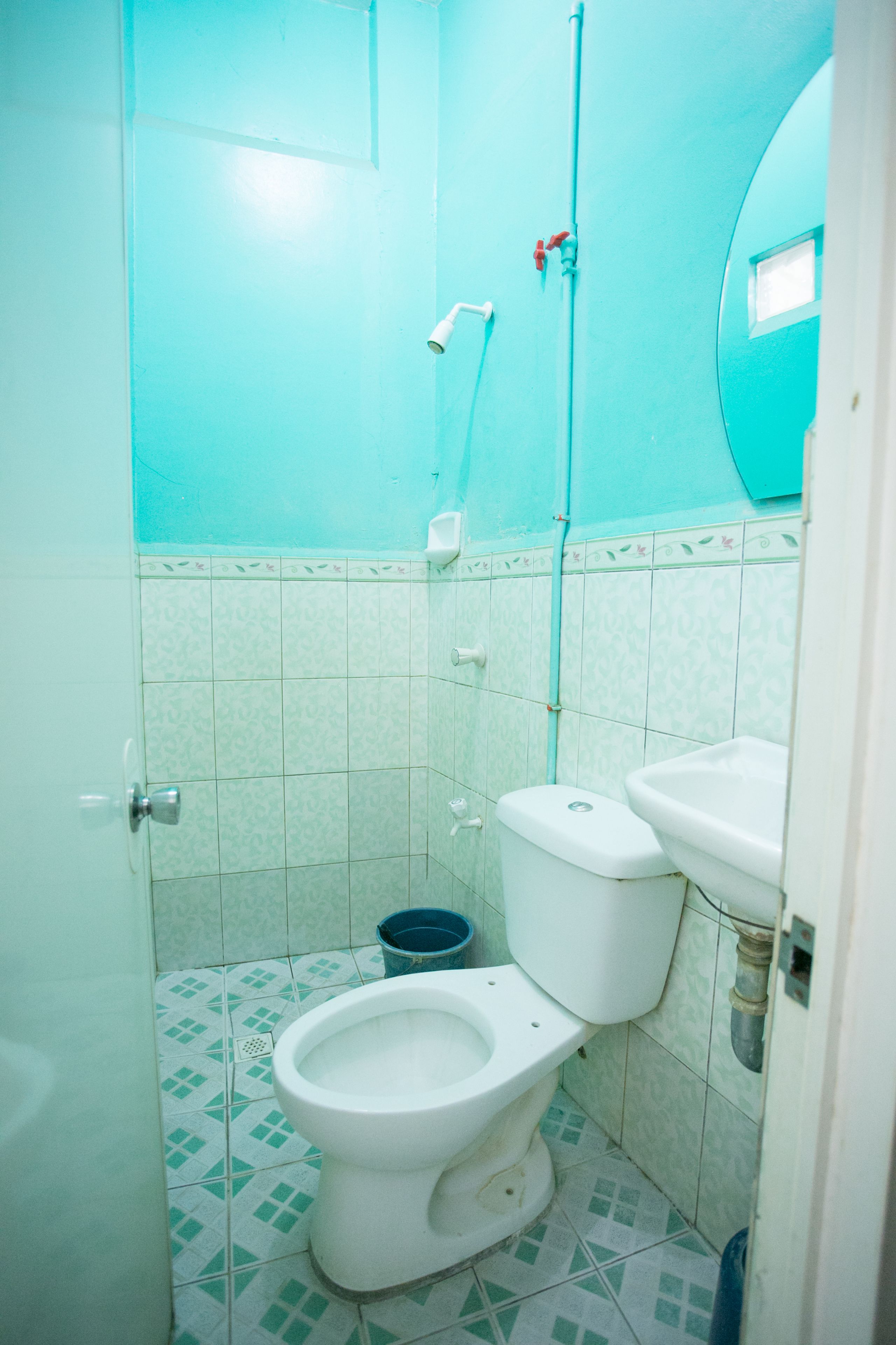 A small bathroom with a toilet, sink, and shower.