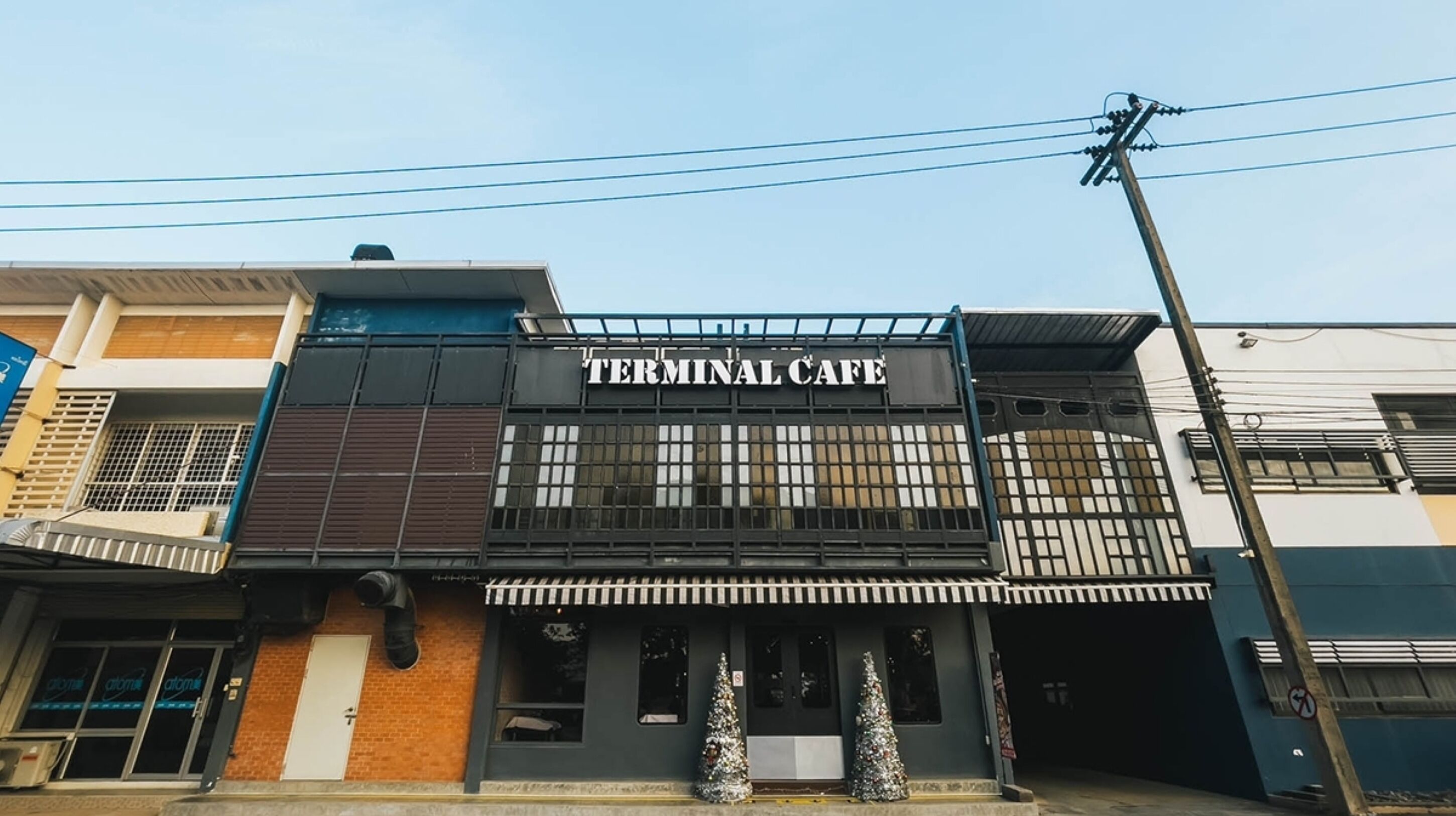 A building with a sign reading "Terminal Cafe" and a balcony with railings.
