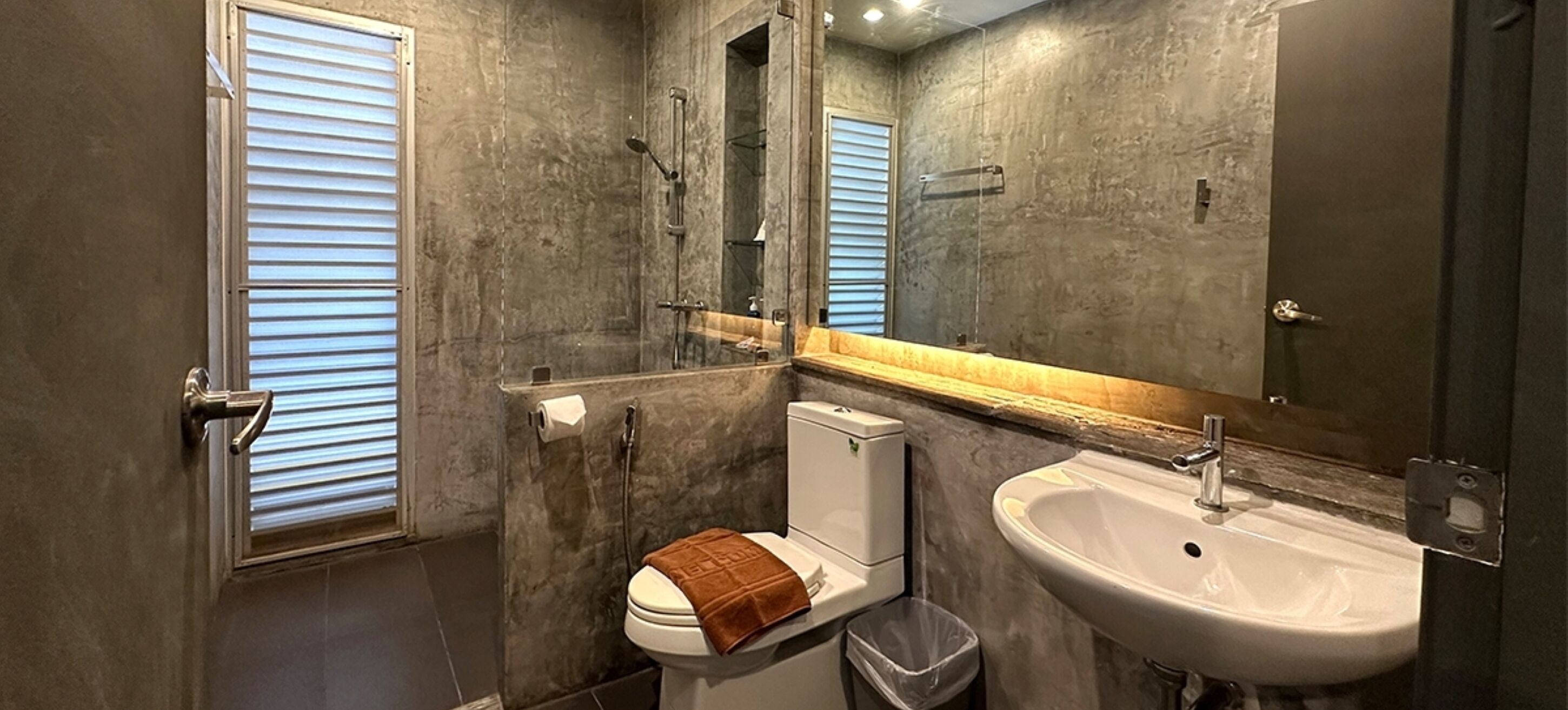 A bathroom with a toilet, sink, and shower.