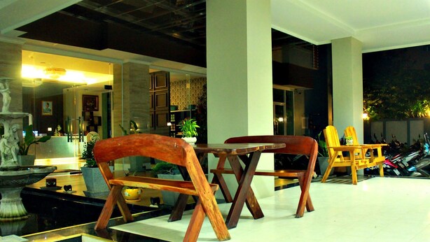 A lobby with wooden chairs, a fountain, and a statue. - Able Resident Hat Yai (Hat Yai)