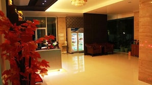 A modern hotel lobby with a reception desk, a refrigerator, and a seating area. - Able Resident Hat Yai (Hat Yai)