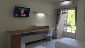 A hotel room with a bed, a desk with a chair, a television on the wall, and a window with curtains. - Able Resident Hat Yai (Hat Yai)
