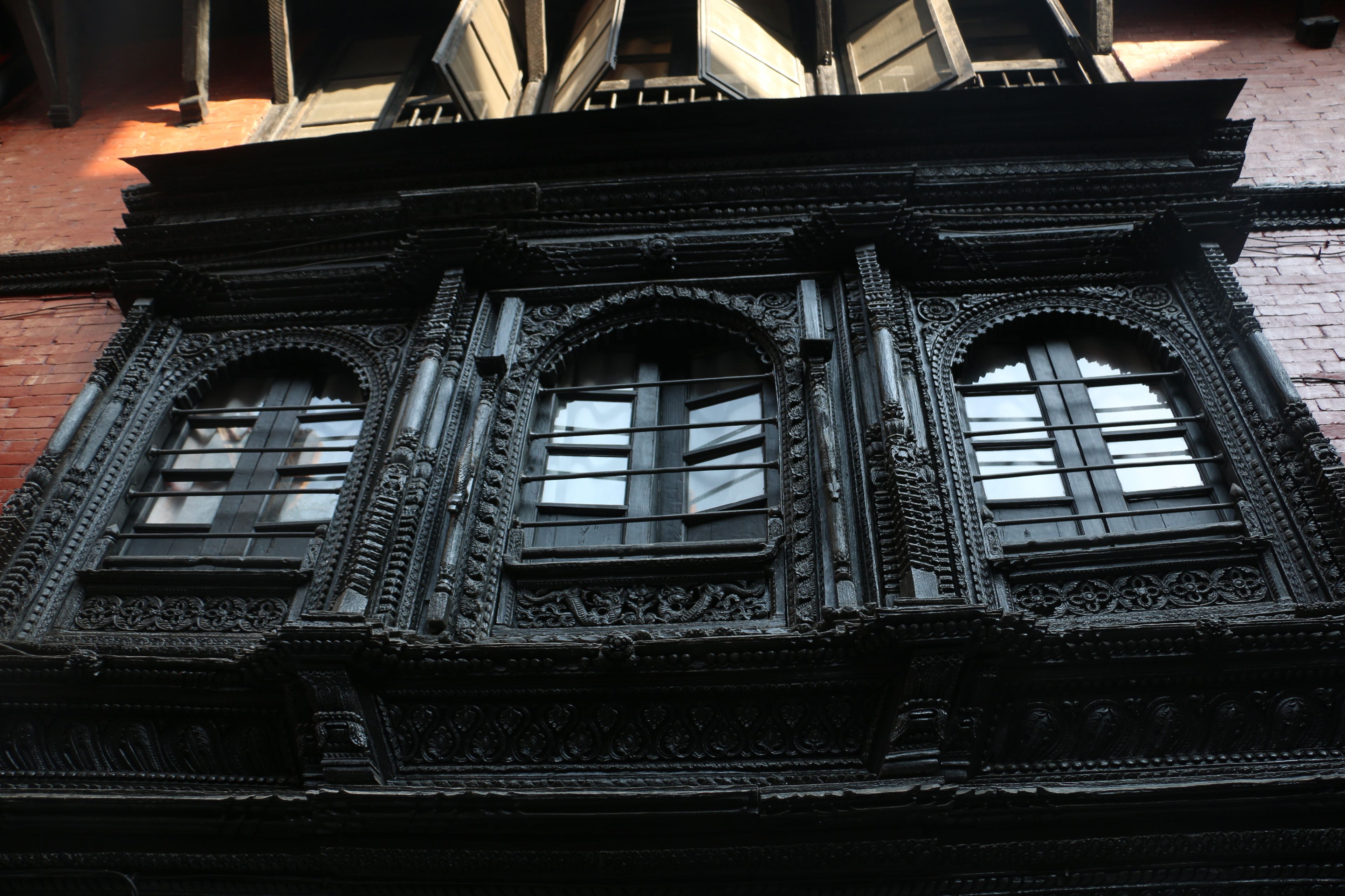 A building facade with ornate architectural details and three arched windows.
