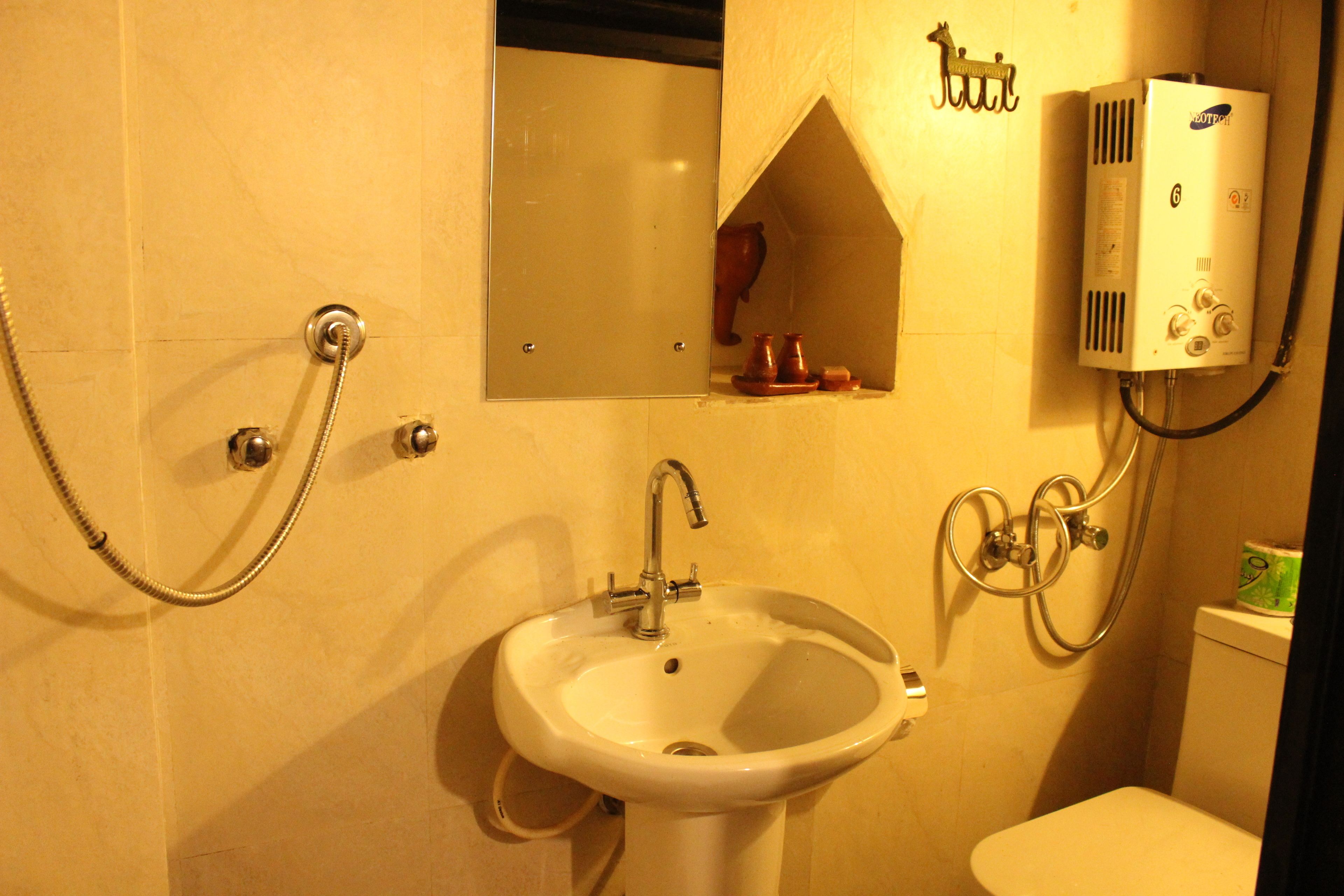 A bathroom with a sink, mirror, shower, and toilet.