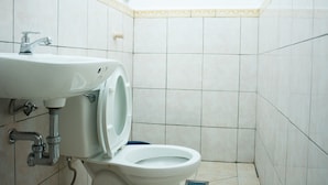 Un baño con inodoro, lavamanos y paredes con azulejos.