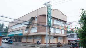 Un hotel con un letrero que dice "GV HOTEL" en un edificio de esquina.