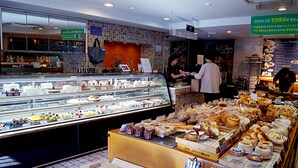 A bakery display with various baked goods and a counter area for service. - Princess Hotel (Seoul)