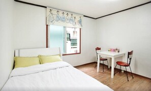 Un dormitorio con una cama, un escritorio y sillas.