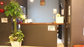 Taulell de recepció amb un senyal que indica el camí als lavabos.