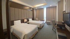 A hotel room with two beds, a TV, a desk, and a chair. - Muong Thanh Xa La (Hanoi)