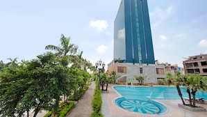 A hotel with a modern design, a swimming pool, and surrounding greenery. - Muong Thanh Xa La (Hanoi)