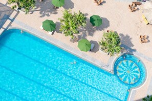 A swimming pool with a circular hot tub, surrounded by lounge chairs and umbrellas. - Muong Thanh Xa La (Hanoi)