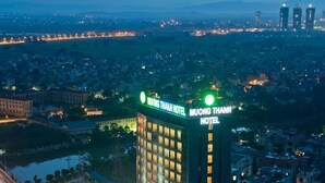 A high-rise hotel with a prominent sign, a swimming pool, and a well-lit facade. - Muong Thanh Xa La (Hanoi)