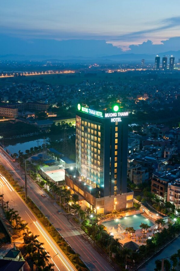 A high-rise hotel with a prominent sign, a swimming pool, and a well-lit facade. - Muong Thanh Xa La (Hanoi)
