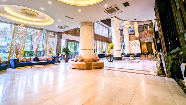A spacious lobby with a central column, seating areas, and large windows. - Muong Thanh Xa La (Hanoi)