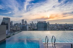 An infinity pool with a city skyline view at sunset. - Amara Bangkok (Bangkok)