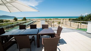 A terrace with a table and chairs overlooking a beach. - Medea Beach Resort (Capaccio-Paestum)