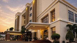 A multi-story hotel with a modern design, featuring a prominent entrance with a covered area and a staircase leading to the main entrance. - Riss Hotel Malioboro (Yogyakarta)