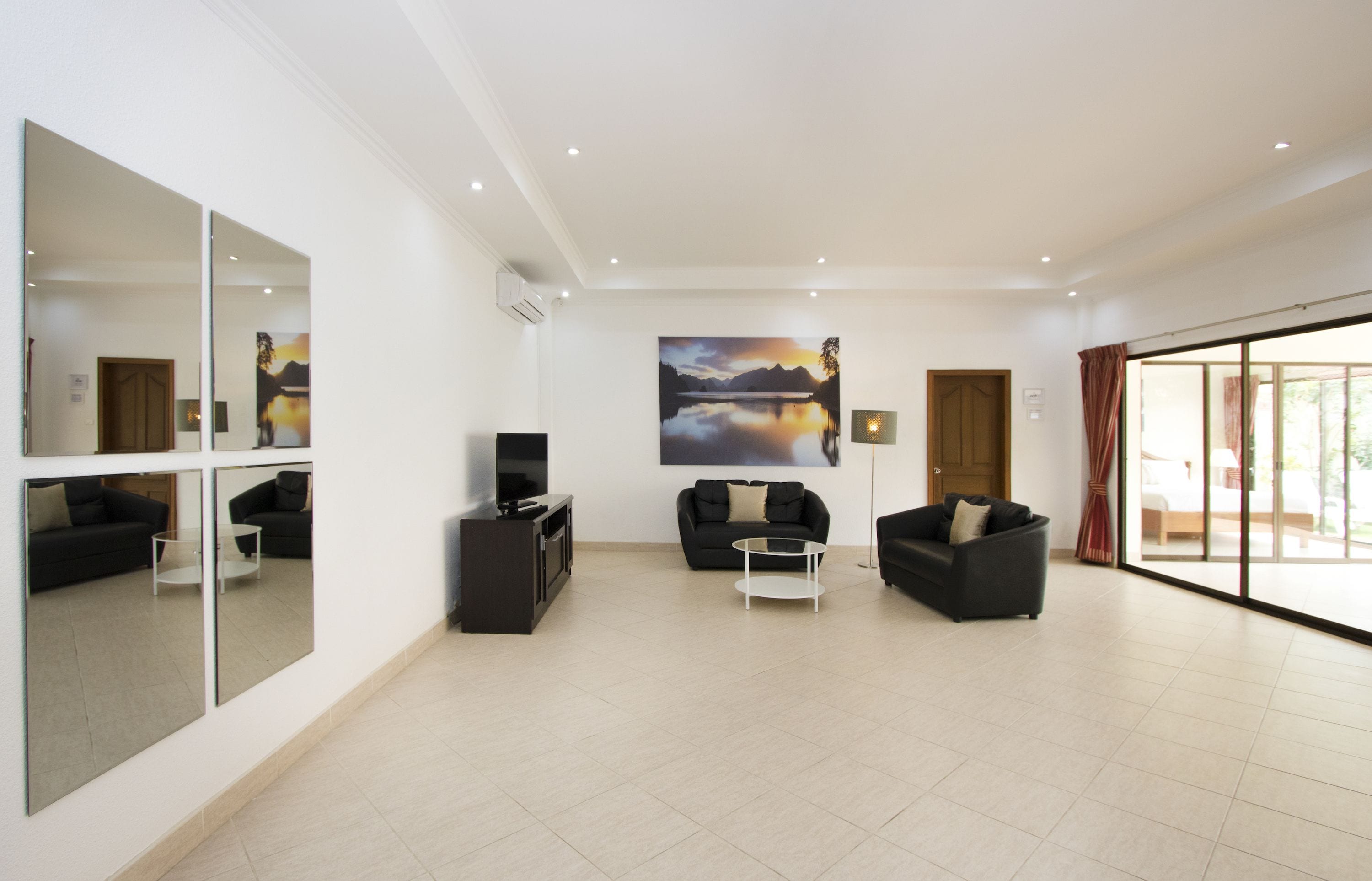 Un salon spacieux avec deux canapés, une table basse et un grand miroir.