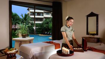 Experience serene spa services in a tranquil setting with a view of the pool and lush greenery.