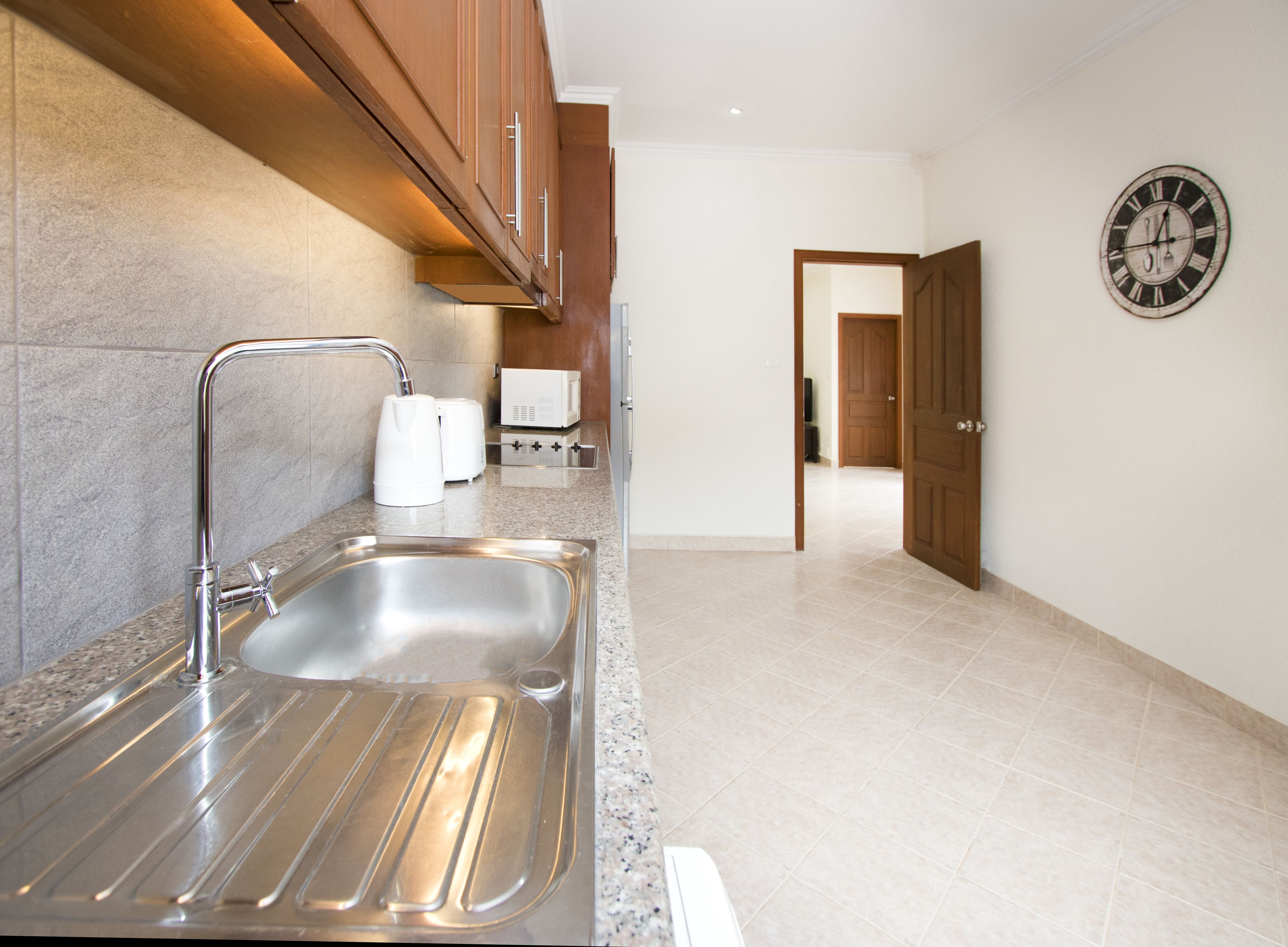 A modern kitchen with stainless steel appliances, a built-in sink, and wooden cabinets.